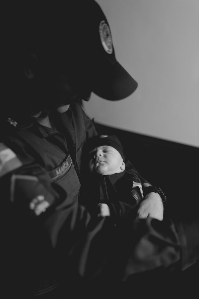 Crno-bela fotografija policajca koji drži bebu, zaštite dece