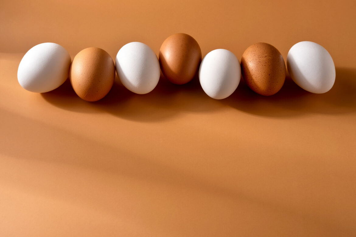 Brown  and white chicken egges on beige background. Chicken eggs jaja