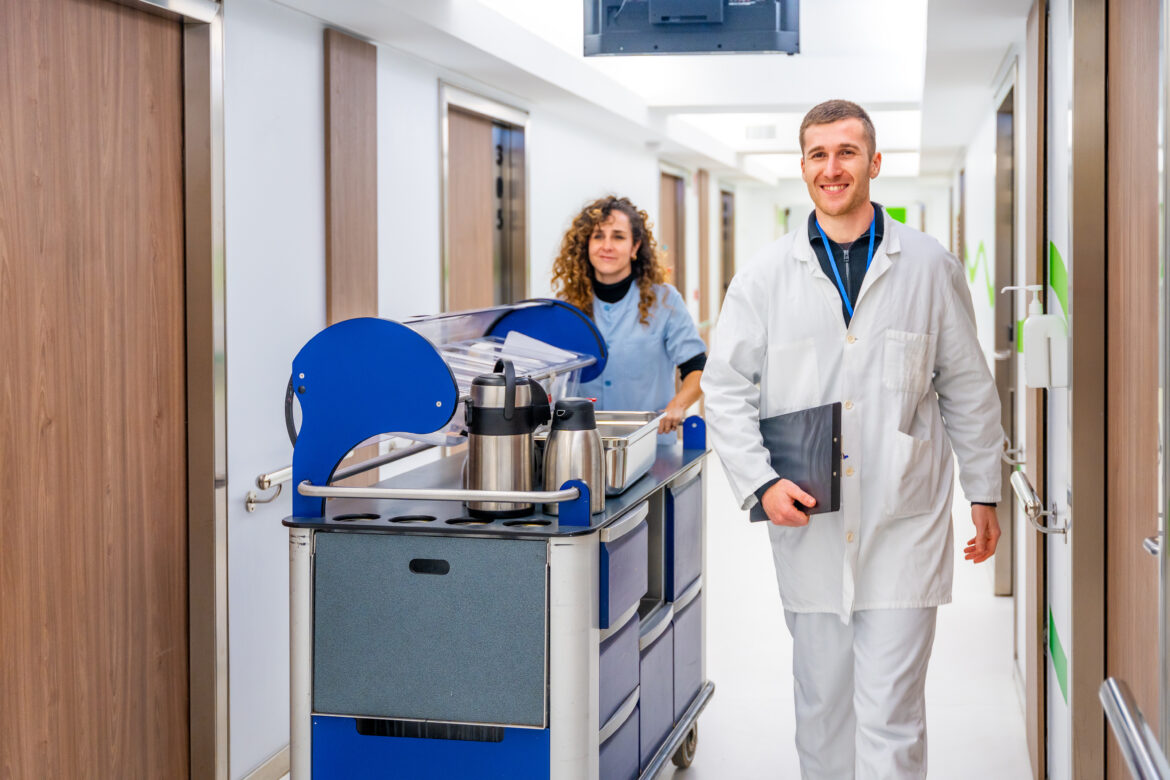 Doctor next to a nurse with a trolley with coffee Čigota