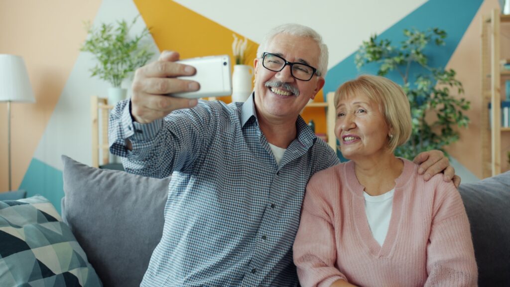 stariji par snima selfi na sofi